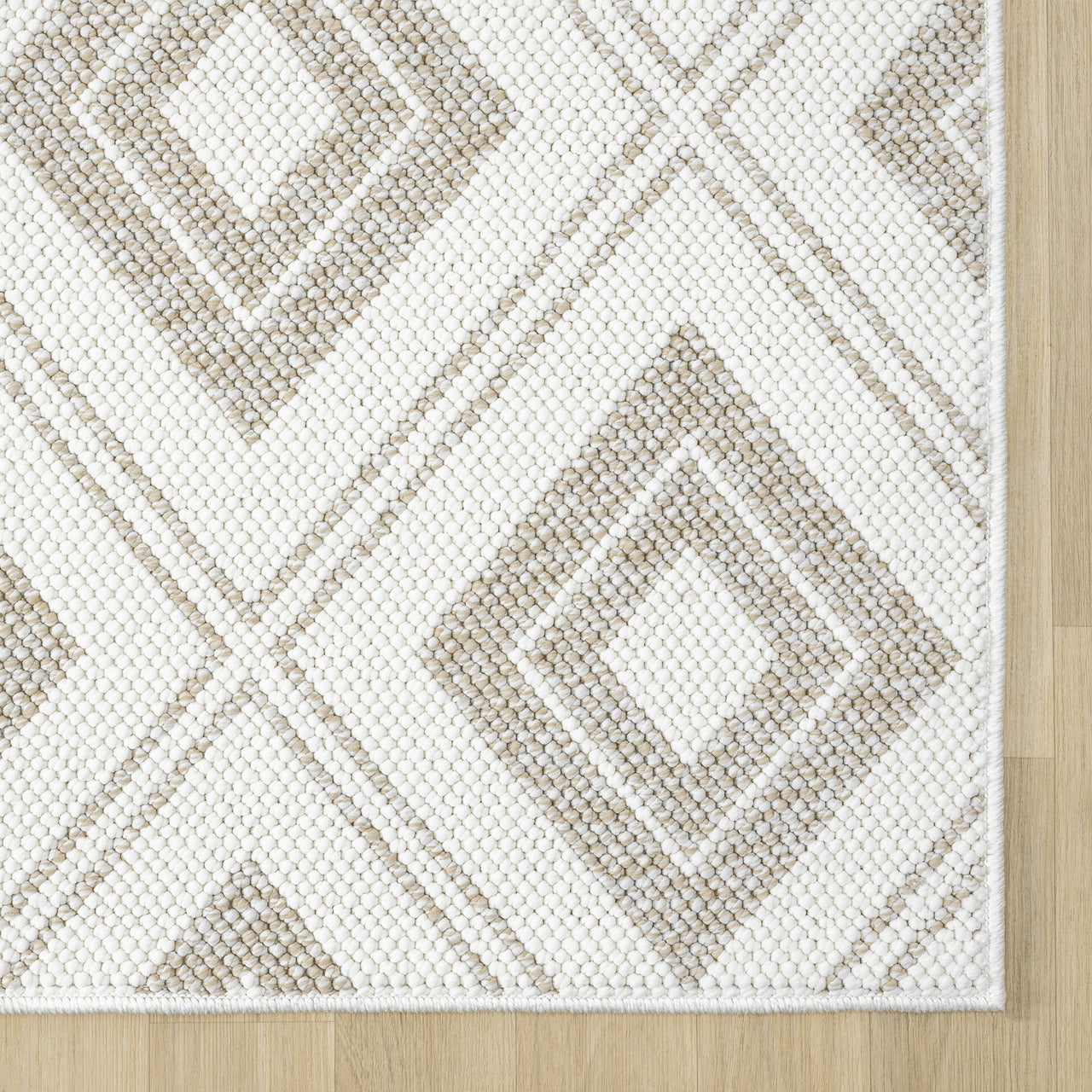 Cream flatweave rug with beige diamond geometric pattern and neatly finished edges on wooden floor.