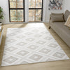 Cream flatweave rug with beige diamond geometric pattern on light hardwood floor.