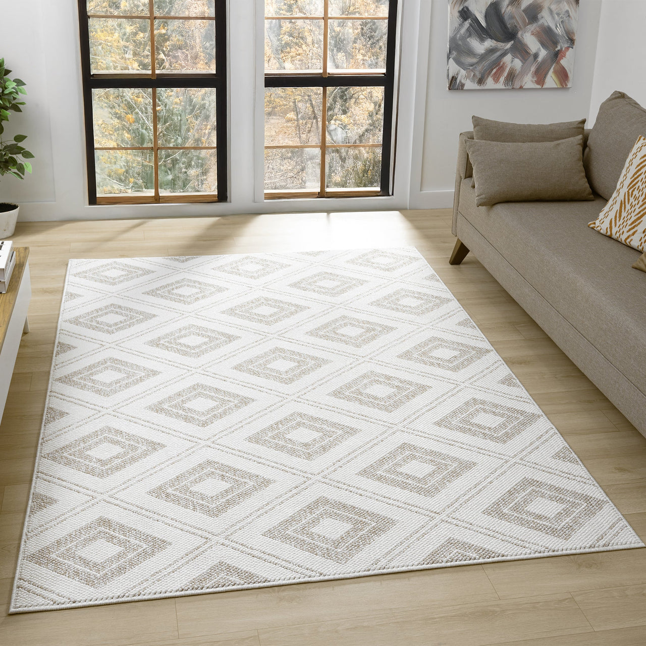 Cream flatweave rug with beige diamond geometric pattern on light hardwood floor.