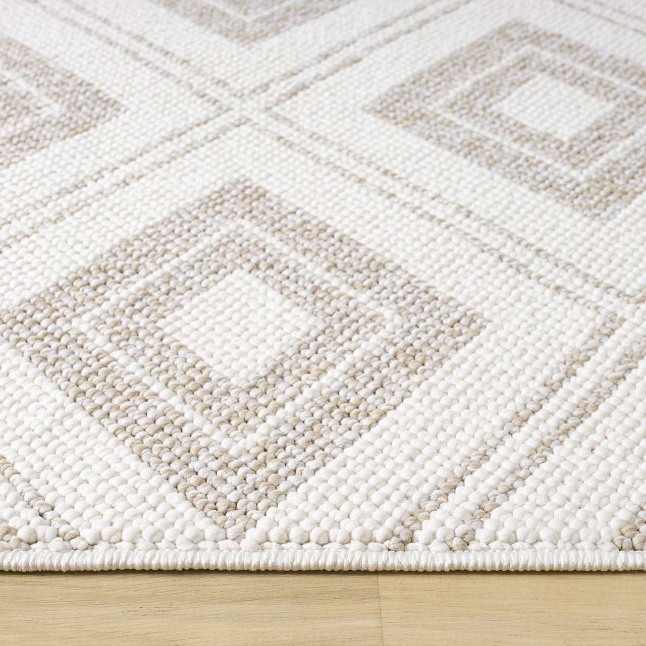 Cream flatweave rug with beige geometric diamond pattern and textured design on hardwood floor.