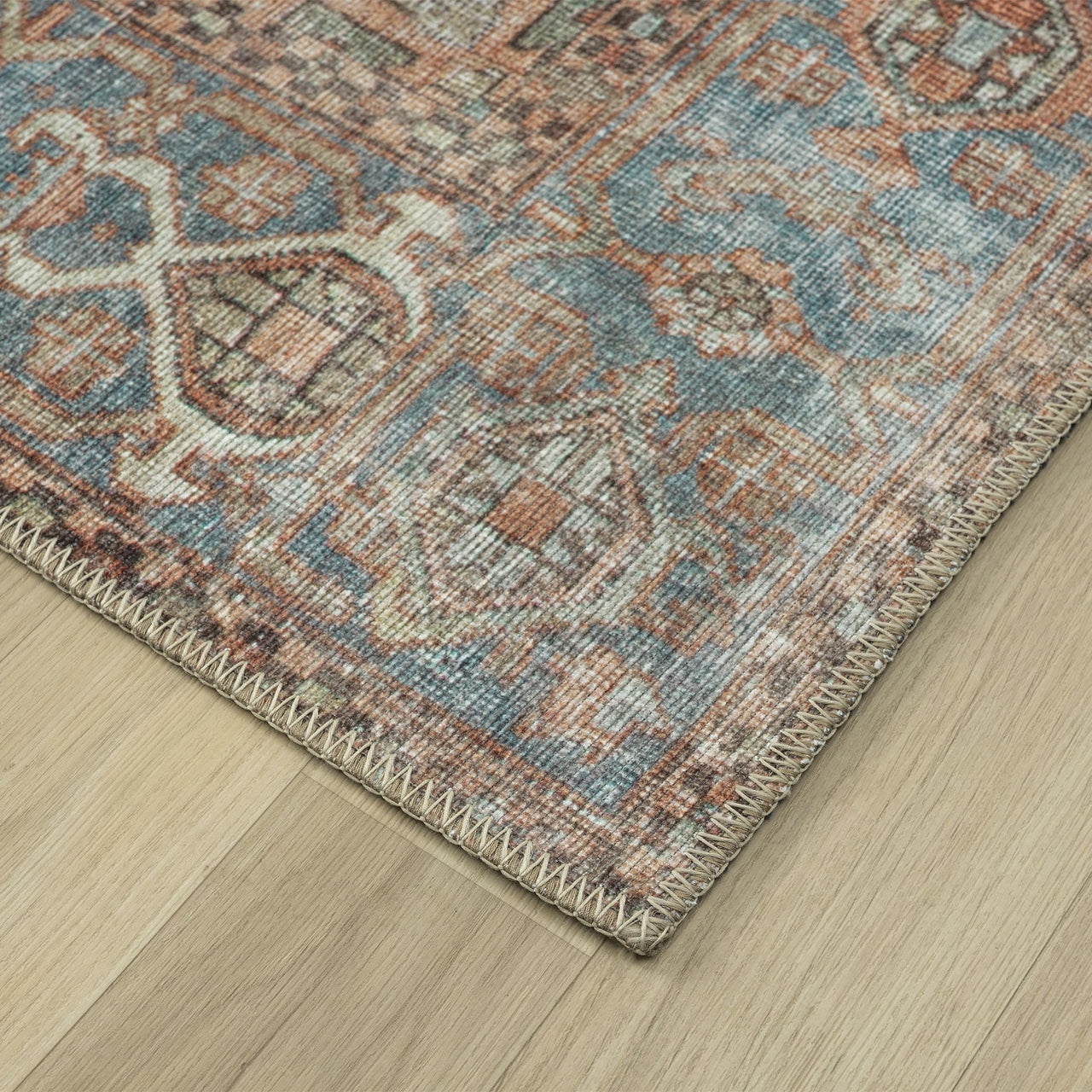 Multicolored traditional runner rug with intricate floral and geometric patterns in muted blue, rust, and beige tones.