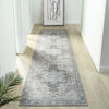 Grey multi-colored traditional runner rug with faded floral and geometric patterns on light wood floor.