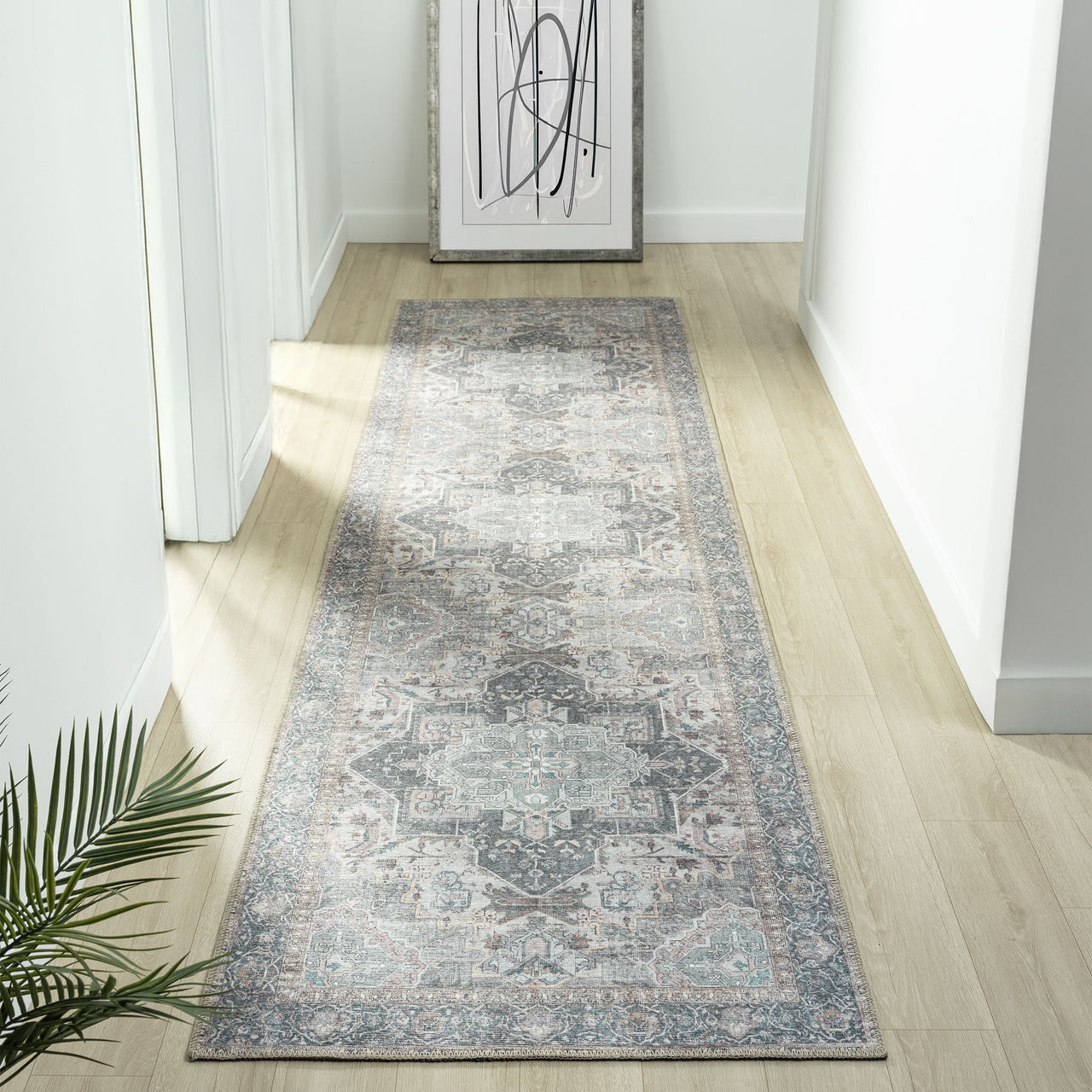 Grey multi-colored traditional runner rug with faded floral and geometric patterns on light wood floor.