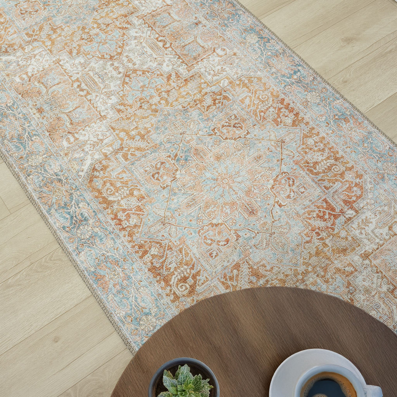 Traditional runner rug with muted orange and blue floral motifs on a distressed cream background.