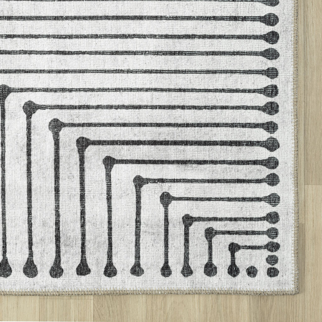 Black and white geometric patterned flatweave runner rug with beige border.