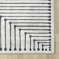 Black and white geometric patterned flatweave runner rug with beige border.