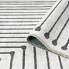 Black and white geometric patterned flatweave runner rug with linear and dot motifs on cream background.