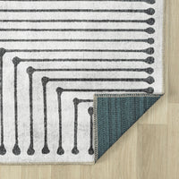 Black and white geometric patterned traditional flatweave runner rug with beige edges and teal backing.