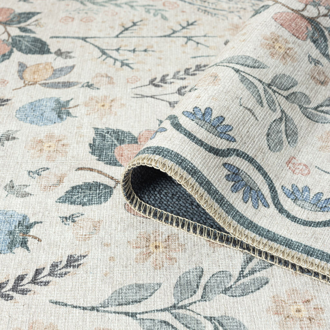 Traditional flatweave runner rug with muted floral and leaf motifs in soft blues, pinks, and greens on a cream background.