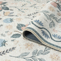Traditional flatweave runner rug with muted floral and leaf motifs in soft blues, pinks, and greens on a cream background.
