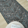 Grey traditional runner rug with multi-coloured floral pattern and subtle blue border on light wood floor.