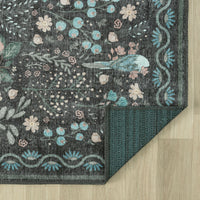 Grey floral patterned traditional runner rug with blue bird and multi-colored accents, corner folded to show textured back.