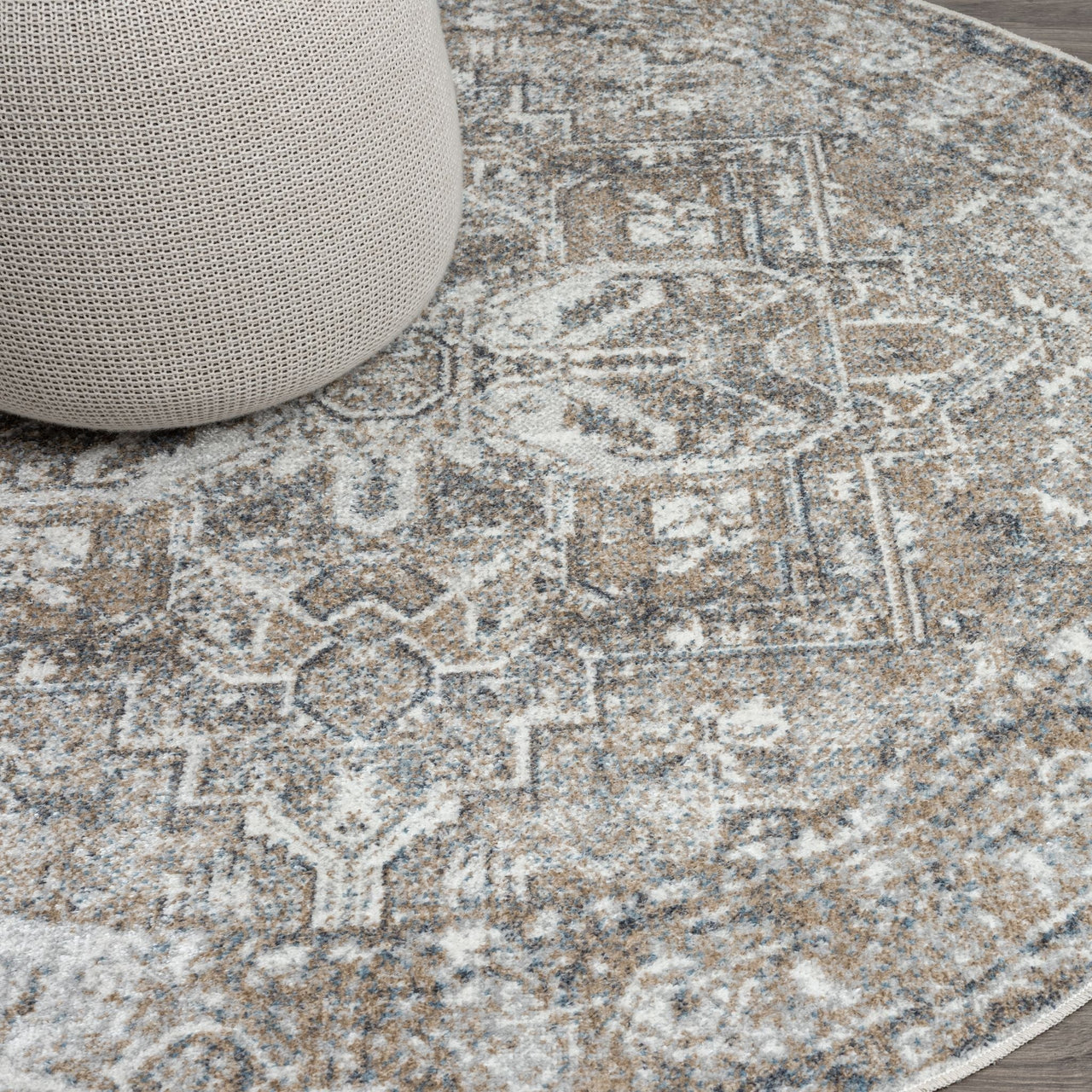 Round rug with intricate multi-color geometric and floral patterns in muted earth tones.