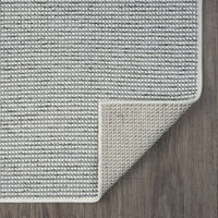 Grey flatweave runner rug with subtle geometric textured pattern and clean stitched edges on wood floor.
