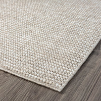 Taupe flatweave runner rug with subtle woven texture and clean stitched edges on wooden floor.