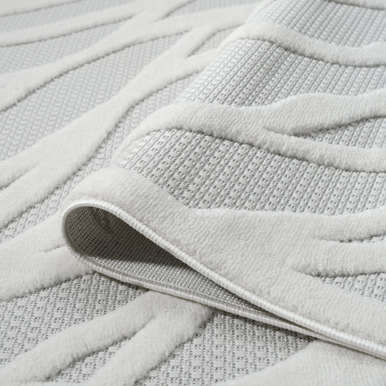 Ivory geometric patterned runner rug with raised textured design and woven polypropylene pile.