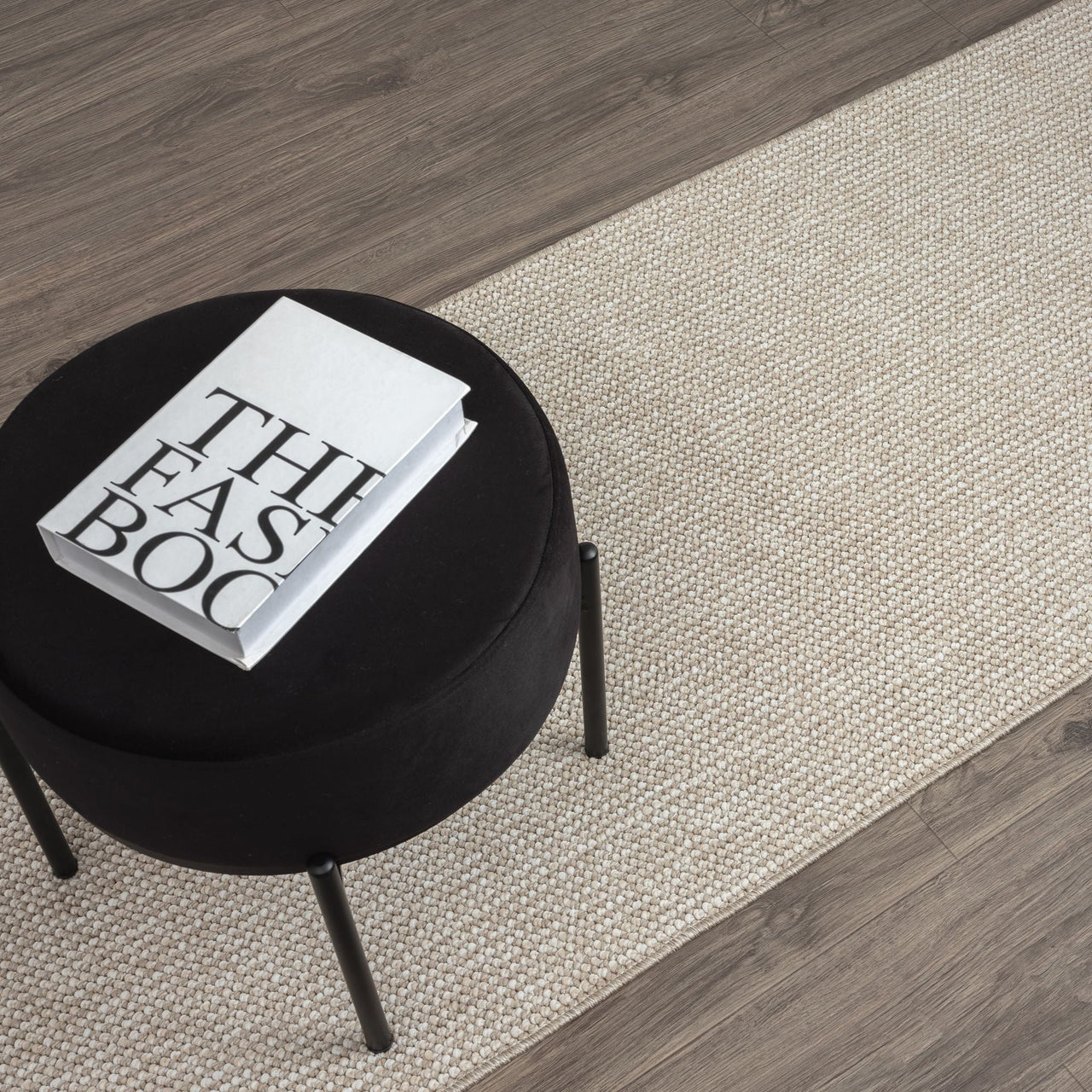 Taupe flatweave runner rug with subtle geometric pattern on dark wood floor.