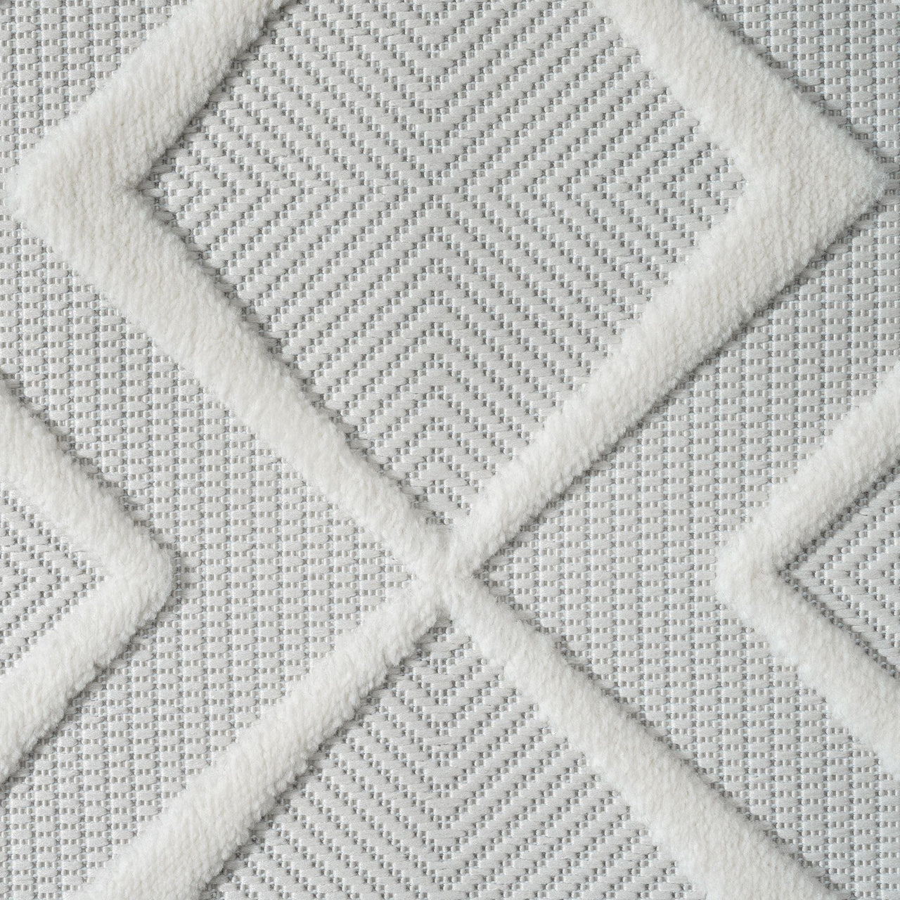 White rug with textured geometric diamond pattern and subtle gray woven background.