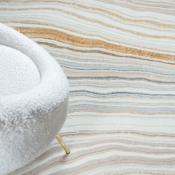 Textured rug with wavy pattern and a white textured chair corner.