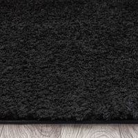 Black modern shaggy rug with dense, soft polyester fibers and a plush texture.