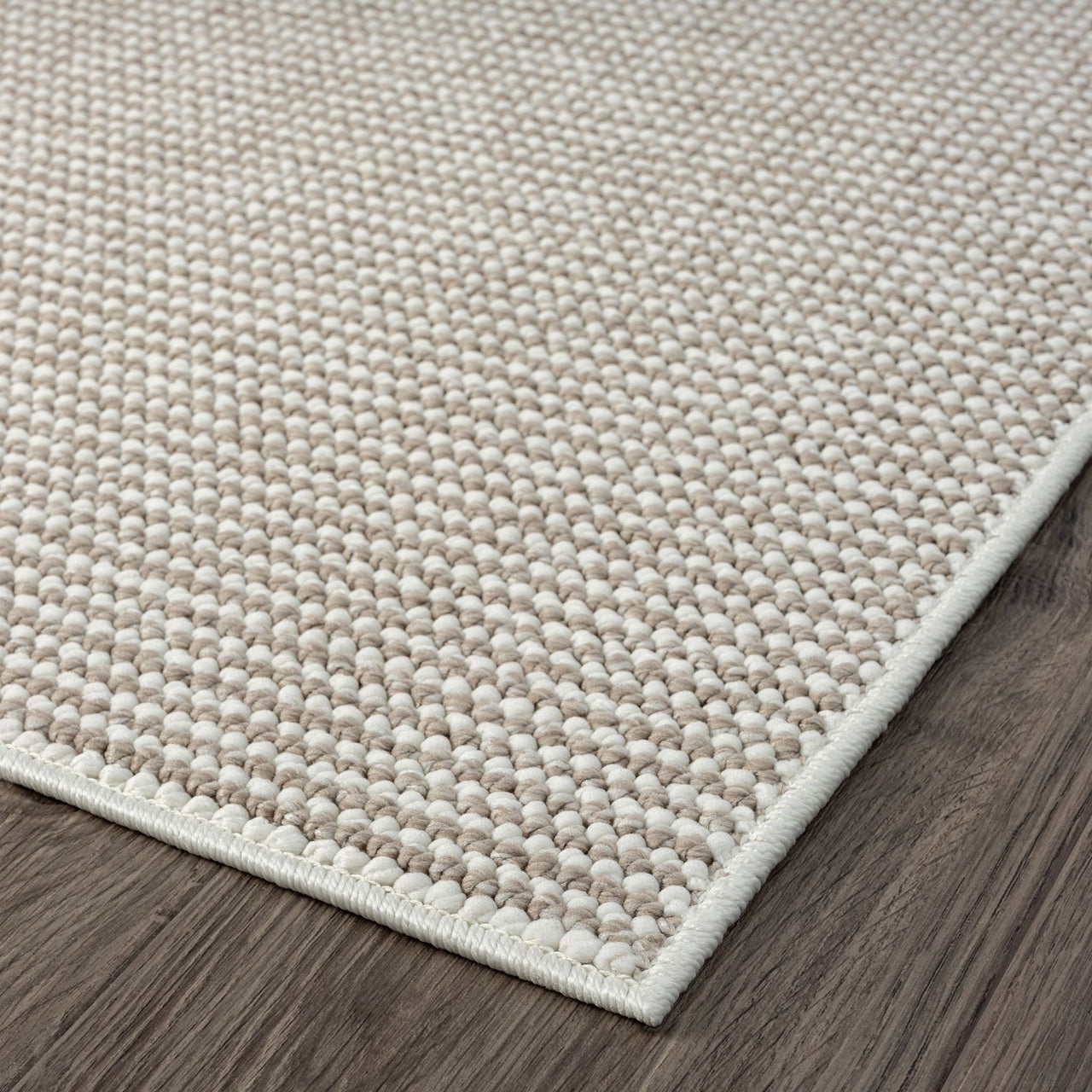 Beige flatweave runner rug with subtle textured geometric pattern and clean edges on dark wood floor.