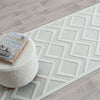 White runner rug with textured geometric diamond pattern on light neutral background.