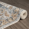 Rolled modern runner rug in muted blue, beige, and brown with a distressed, transitional pattern on wood floor.