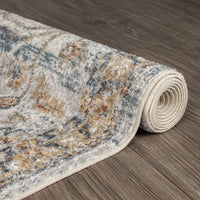 Rolled modern runner rug in muted blue, beige, and brown with a distressed, transitional pattern on wood floor.