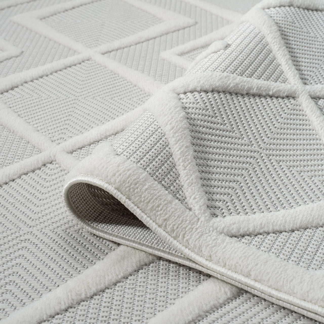 White modern runner rug with raised geometric diamond pattern and textured polypropylene pile.