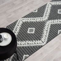 Grey and white modern geometric patterned runner rug with textured pile and fringed edges.