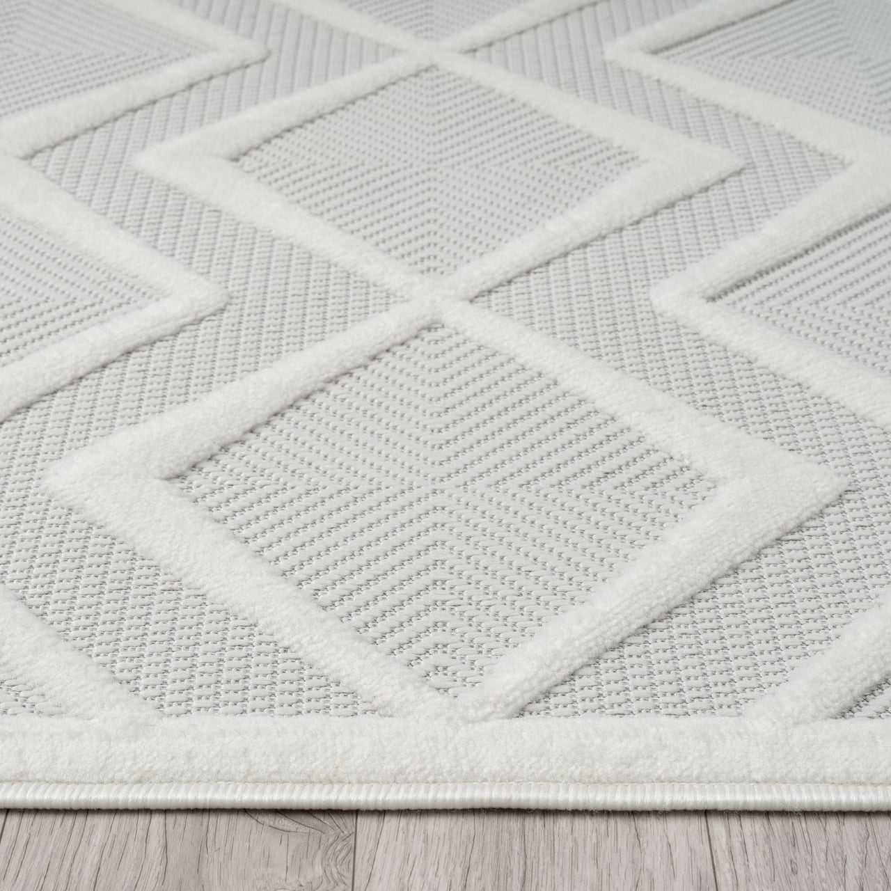White runner rug with raised geometric diamond pattern and textured polypropylene pile.