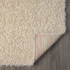 Beige modern shaggy runner rug with thick polyester fibers and rounded corners, corner folded to show striped backing on.
