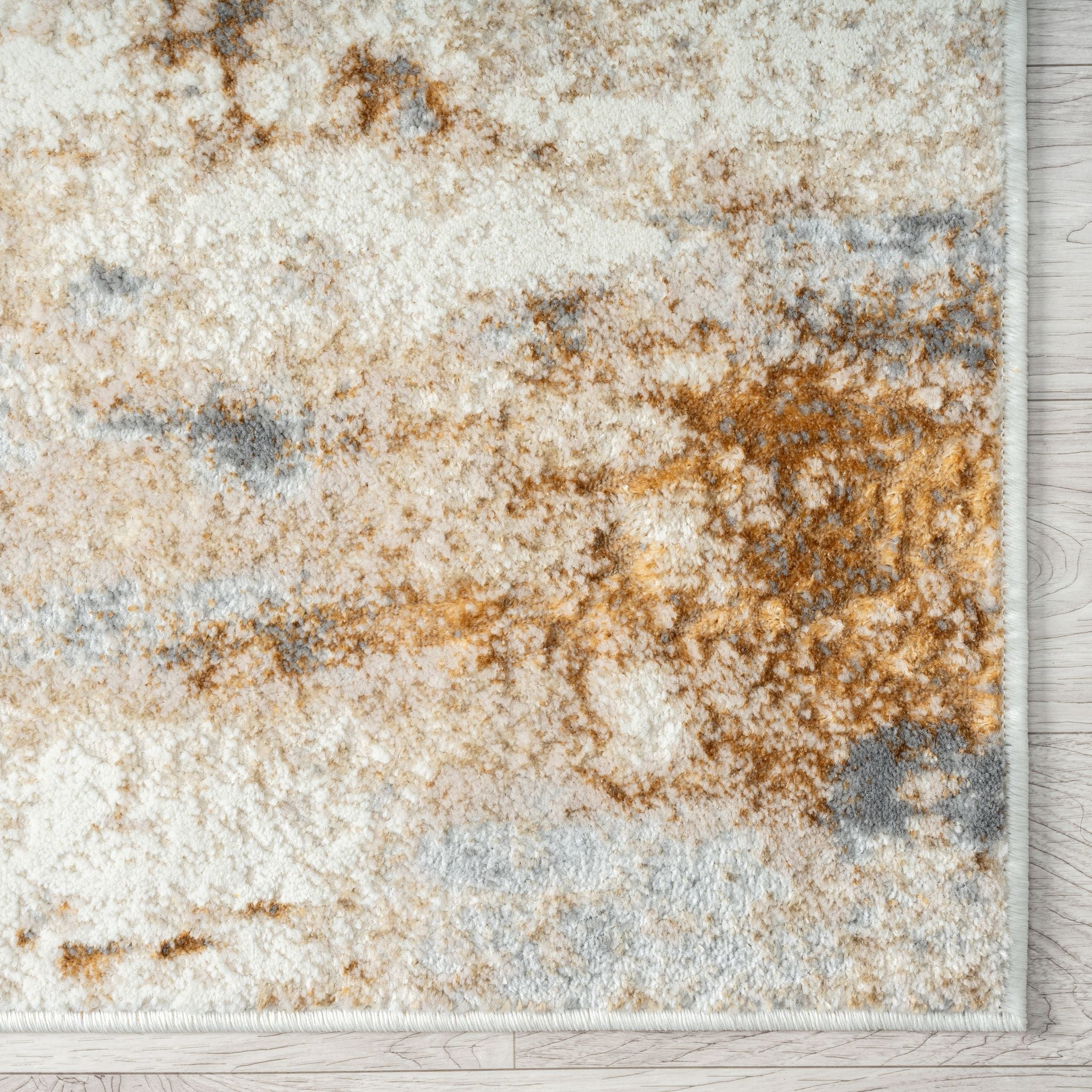 Textured area rug with brown, beige, and gray pattern on a wooden floor.