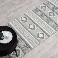 Grey and beige runner rug with modern geometric diamond and stripe pattern, fringed edges.