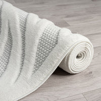 Ivory runner rug with textured geometric pattern and soft polypropylene pile on light wood floor.