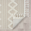 Beige and cream runner rug with textured geometric diamond pattern and fringed edges on light floor.