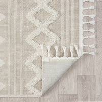 Beige and cream runner rug with textured geometric diamond pattern and fringed edges on light floor.