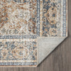 Multicolored coral and blue transitional rug with distressed pattern and folded corner showing texture.