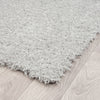 Light grey shaggy runner rug with thick polyester pile on light wood floor.