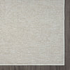 Beige flatweave rug with subtle geometric pattern and a clean stitched edge.