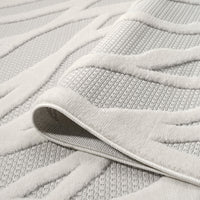 Ivory rug with raised geometric linear pattern and textured polypropylene pile.