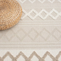 Beige and cream round rug with textured geometric diamond patterns and fringed edges.