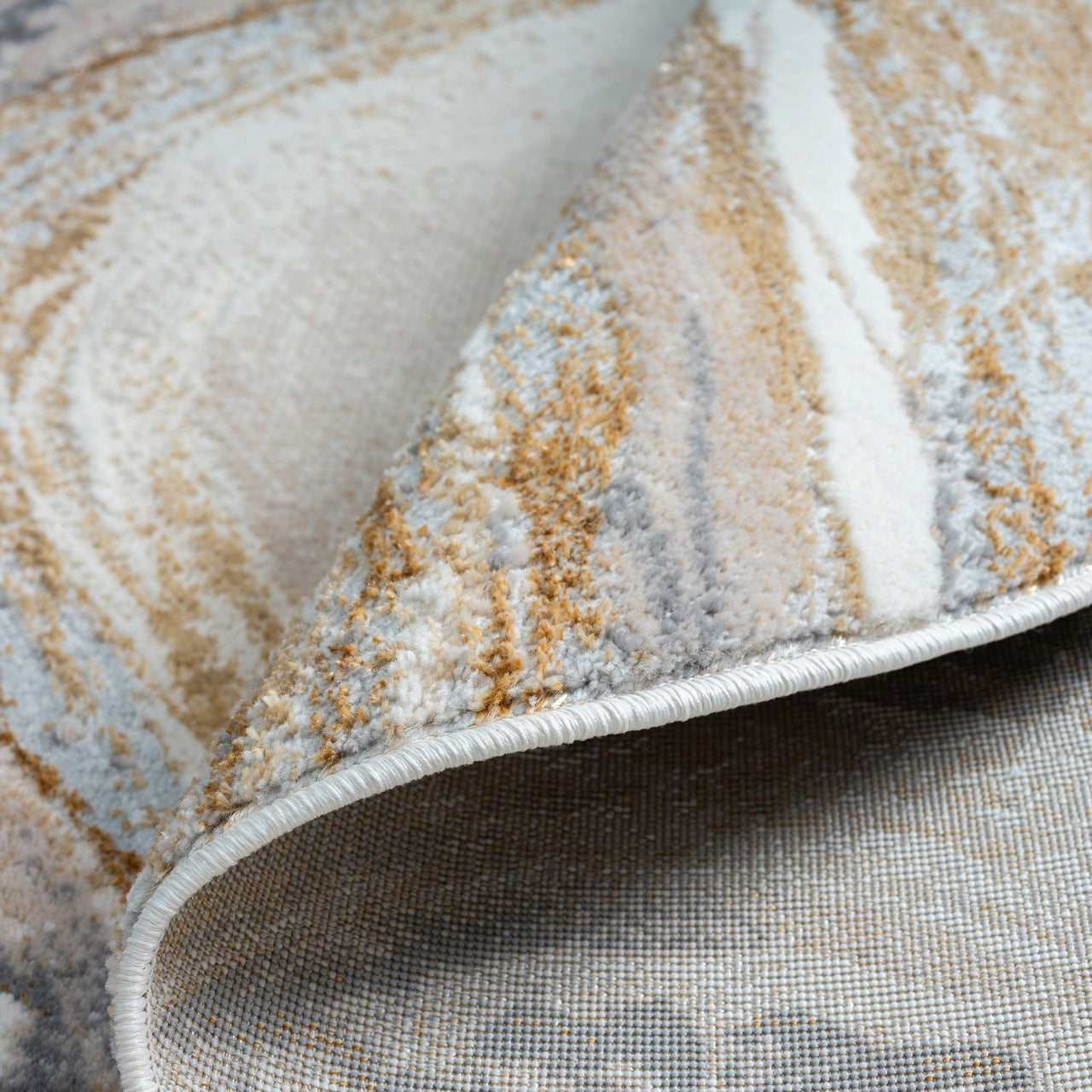 Close-up of a textured rug with brown, beige, and gray colors.