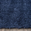 Navy blue modern shaggy rug with plush polyester fibers on wooden floor.