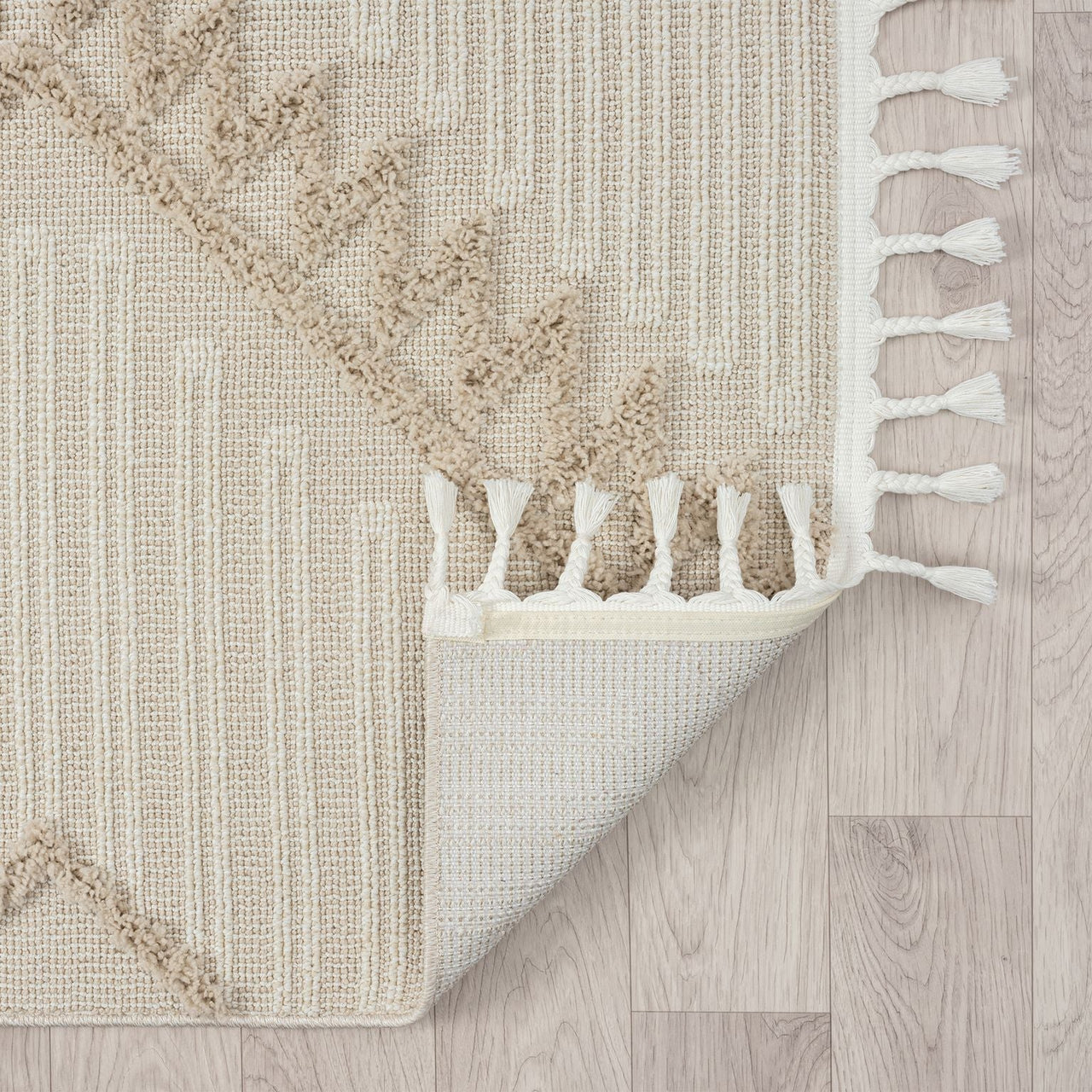 Taupe and beige runner rug with modern geometric pattern and white fringed edges on light wood floor.