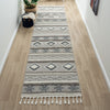 Grey and beige runner rug with modern geometric patterns and fringed edges on hardwood floor.