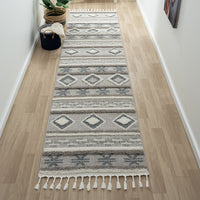 Grey and beige runner rug with modern geometric patterns and fringed edges on hardwood floor.