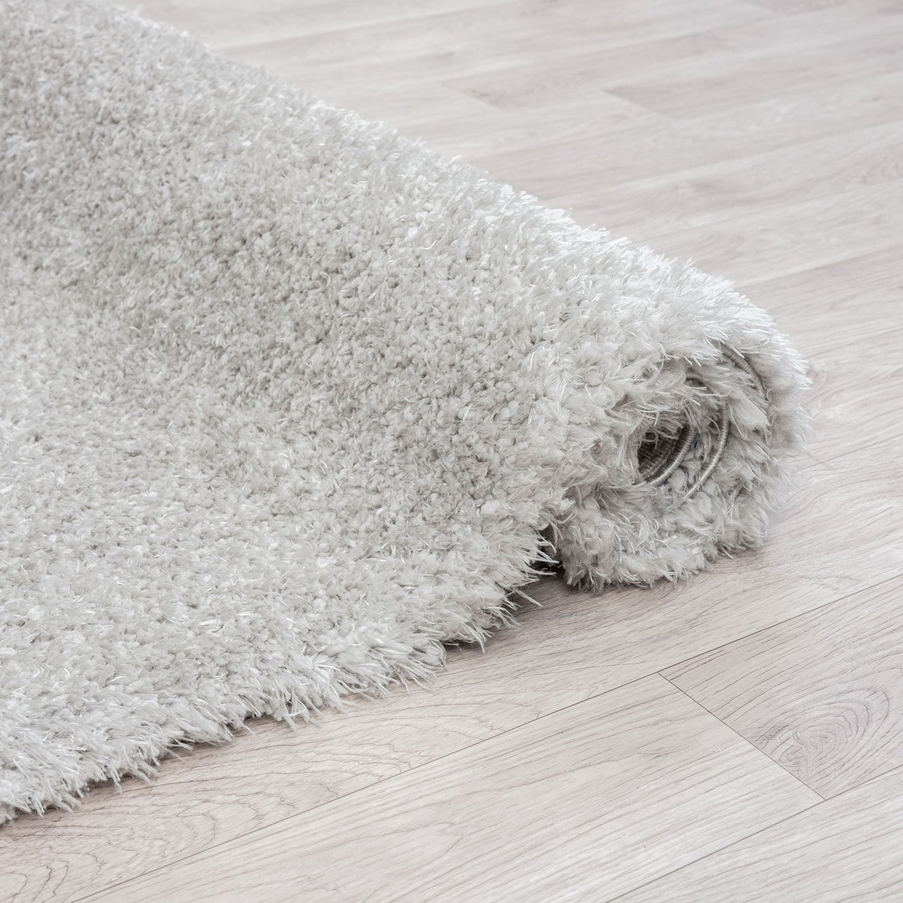 Light grey modern shaggy runner rug with dense, plush polyester fibers on light wood floor.