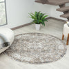 Round multi-colored rug with intricate geometric patterns in neutral tones on light wood floor.