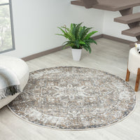 Round multi-colored rug with intricate geometric patterns in neutral tones on light wood floor.